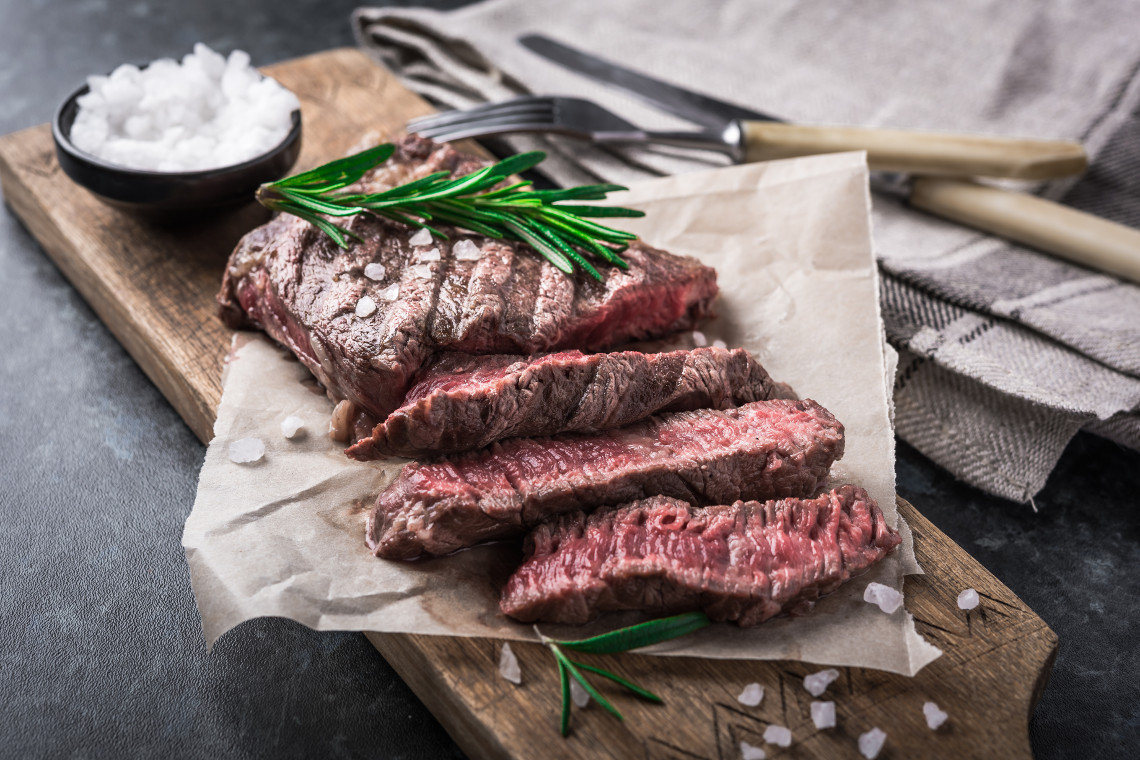 Grilled beef steak with rosemary and salt on cutting board